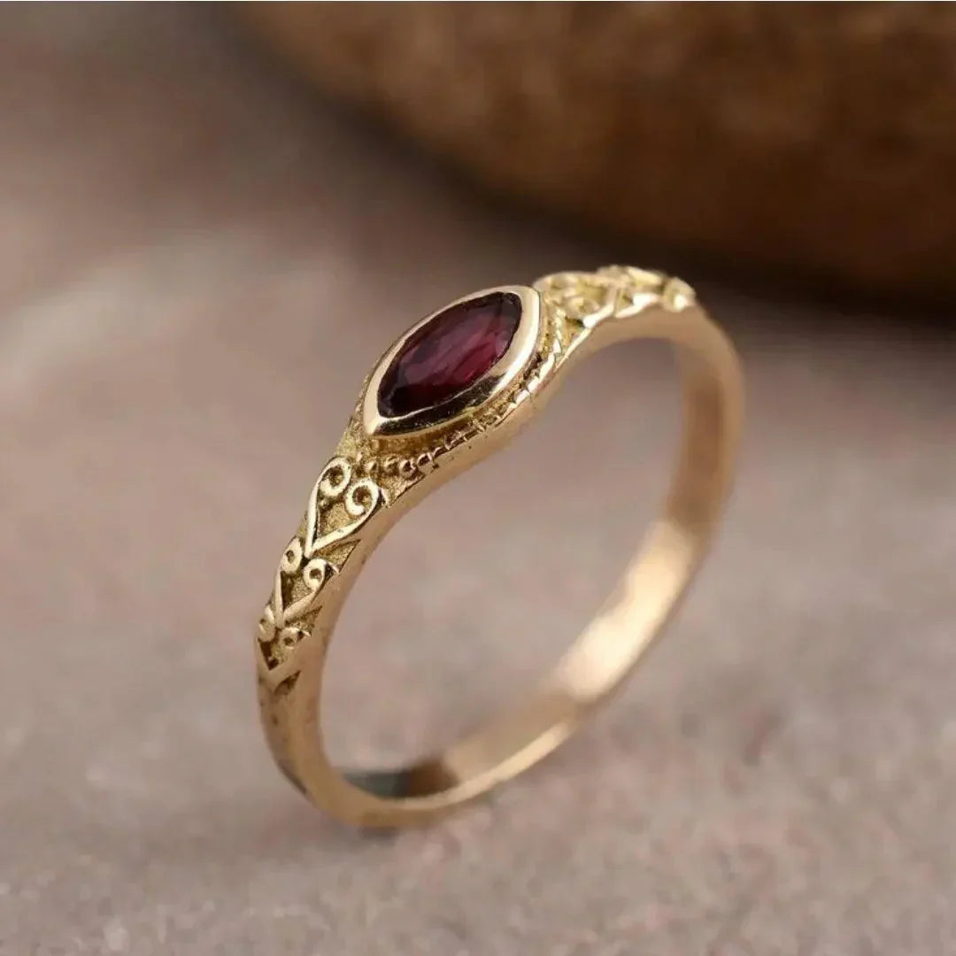 Elegant guldring med en rød zirkonia