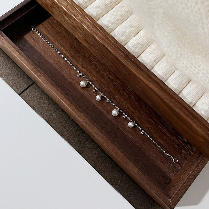 Sølvarmbånd med elegant perle og diskrete detaljer