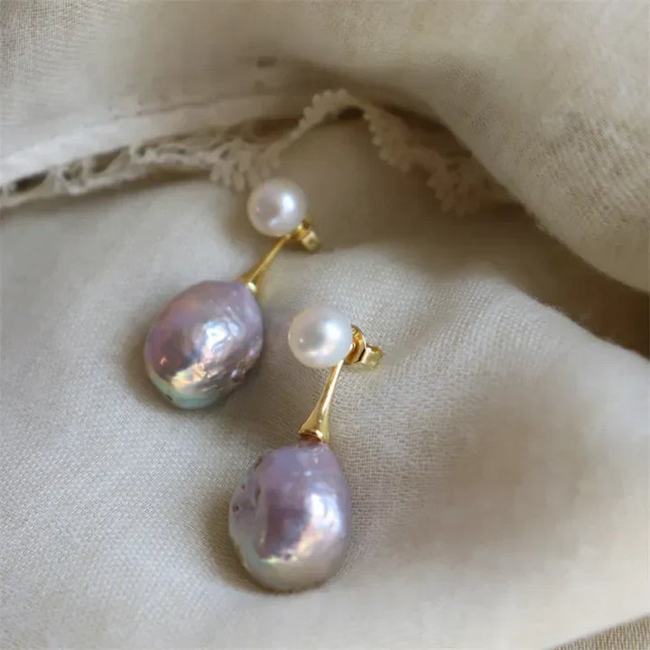 Elegante guldfarvede øreringe med lilla perle
